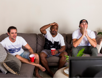 Group of mates watching a sports game from couch