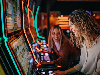 two young women playing poker machine