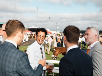 group of men watching a horse race